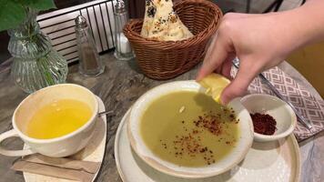 närbild av person tillsats citron- juice eller äta grädde soppa med lax fisk och dill citron- juice grädde soppa video