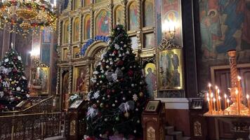 kerk Kerstmis orthodox kerk binnen Kerstmis vooravond decoraties Kerstmis boom kaarsen mooi pictogrammen geboorte van Jezus Gefeliciteerd rinkelen klokken viering video