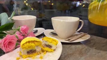 amarelo Macarrão e citrino chá Rosa rosas celebração amantes chá festa dois copos lindo pratos tarde em rua cortar limão sobremesa dividir tudo dentro metade entre dois. hortelã limão laranja dentro chá video