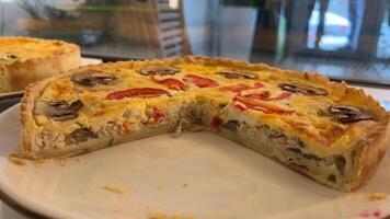 ampla salgado recipiente com cogumelos e tomates com queijo com espinafre, salmão e brócolis delicioso lanche almoço dentro uma restaurante em exibição atrás vidro em branco pratos escolha do torta video