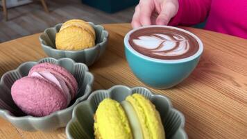 caldo cioccolato macarons verde tazza di il caldo cioccolato e verde amaretti con st patricks giorno attributi al di sopra di messa a fuoco. lento movimento. video