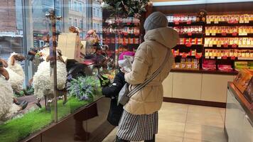 Vinnitsa Ukraine 01.18.2024 Roshen sweets store. decoration sale cash register candy logo. people looking at lambs on display. children joy candy Evening Kyiv sweet life video