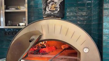 Traditional Italian pizza is baked in a stone wood-burning oven in a modern pizzeria. Pizza concept. video