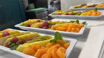 snijdend fruit en bessen Aan een bord. feestelijk tafel met heerlijk snacks. Super goed selectie, wet de trek. bruiloft video