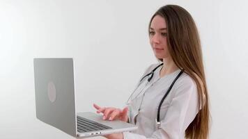 Mädchen Arzt jung Licht Hintergrund Studio Tag schön einer positiv Tablette suchen lächelnd Konzept von Fernbedienung Kunde Pflege online Patienten. video