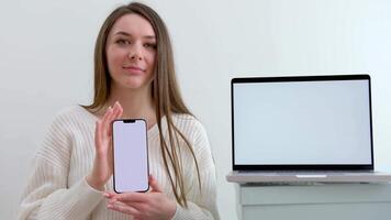 Jeune mignonne magnifique fille avec une téléphone dans sa mains tourné le écran espace pour La publicité texte suivant à portable sur des boites livraison génial un service excellent équipe travail pour louer La publicité fermer video