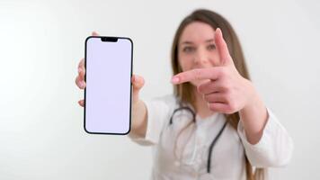 jung Mädchen Krankenschwester zeigen Finger beim Telefon mit leer Raum zum Anzeige Text medizinisch Ergänzungen Tabletten Medizin Behandlung online Beratung Anzeige Frau lächelnd Arzt Stethoskop Punkt Finger oben zu Ecke video