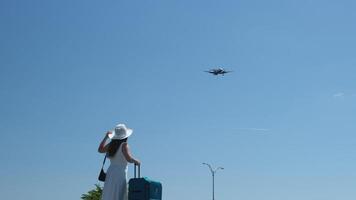 ver desde el espalda de un pequeño bebé niña ondulación mediante un aeropuerto terminal ventana a un tomando apagado chorro. hija diciendo adiós a el partiendo avión. alto calidad 4k imágenes video