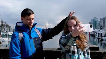 Stanley Park Teen Gehen nehmen Bilder täuschen um suchen beim Bäume chatten Frühling cool Wetter Touristen Rucksäcke Telefone Spaß zuerst Datum gehen halt Hände Junge und Mädchen Schulkinder schießen video