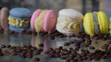 French macaroons, coffee beans and a cup of black coffee on the table close-up. video