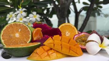 Sweet juicy ripe yellow mangoes on a green background under harsh shadow video