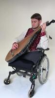 guerre vétéran dans une fauteuil roulant musicien dans broderie pièces kobza fermer âge moyen homme pièces une musical ethnique ukrainien instrument indépendance et invincibilité gloire à Ukraine gloire à héros video