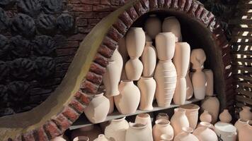 Pottery in the workshop of the master are on the shelves and risers cookware in varying sizes. displayed on an old. wooden table at a market in the Georgian Republic. DCI 4k video