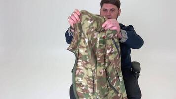 Mens in rolstoel duurt uit overjas van oorlog hij rechtzetten het terwijl onderzoeken het geborduurd overhemd gevolgen van verlies zege vrede leven gaat Aan oekraïens soldaat oorlog veteraan held video