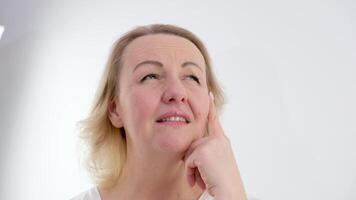 Young woman standing and thinking an idea pointing the finger up over isolated background. video