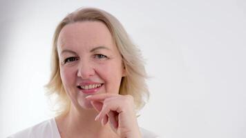 American woman shows a raised index finger, a sign of attention on a white background. woman holding her hand close up. joy consent advertising video