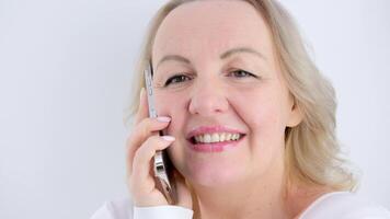 donna contento con gioia gettò sua testa su parlando su il Telefono con piacere beatitudine piacevole emozioni e bellissimo denti carino di mezza età donna nel studio bianca sfondo pubblicità piace un' sincero Sorridi video