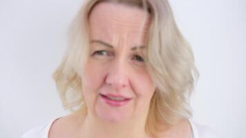 ziek ziek ouderen grijs haar blond vrouw dame Jaren 40 jaren oud in wit overhemd niezen geïsoleerd Aan duidelijk pastel licht blauw achtergrond studio portret. gezond levensstijl ziek ziek ziekte behandeling concept video