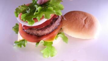 appetitlich frisch Brötchen mit Sesam Saat zu fallen auf das verführerisch saftig groß Burger video