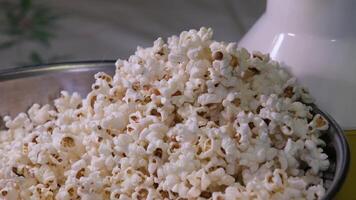 Rühren Popcorn mit ein Löffel Nahansicht im ein Eisen Schüssel vorbereiten Popcorn zum ein Abend Film Anzeigen video