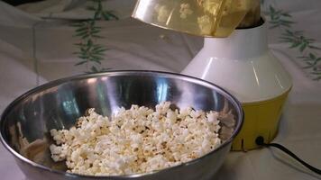 cooking popcorn at home in a special machine caramel filling caramelized popcorn recipe close-up delicious treat for movie stir and pour caramel icing popcorn grains iron utensil appetizing snack video