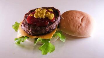 Appetizing fresh bun with sesame seeds to fall on the seductive juicy big burger video