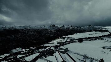 éloigné Montagne village couvert avec neige après orage aérien vue video