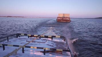 houder aak het zeilen Aan een breed mooi rivier- Aan zonsondergang lucht achtergrond. klem. concept van vervoer, visie van lading schip. video