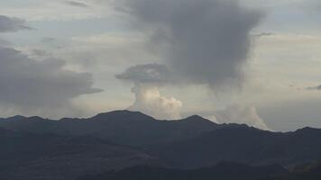 enorme verde montanhas. Ação. zangão Visão do uma lindo panorama Onde você pode Vejo colinas com verde vegetação em eles e névoa com nuvens olhando gostar fumaça. video