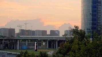 schön Moskau Gebäude. Aktion. ein Landschaft wo modisch hoch Gebäude und Häuser hinter Sie und ein Orange Abend Himmel sind sichtbar. video