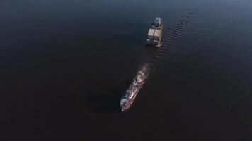 Top view of boat with cargo floating on river. Clip. Beautiful landscape with cargo boat floating on river. Cargo delivery by boat with trailer. Sea cargo transportation video
