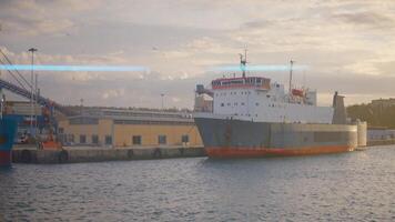 Ship at seaport on summer day. Action. Loading of goods on ships and steamers at seaport. Maritime shipping industry and trade video