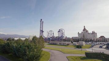 Panorama of amusement park with castle in summer. Action. Top view of beautiful roller coaster with palace. Amusement park on green meadow on summer day video