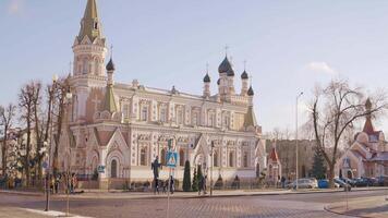 Pokrovsky Cathedral. Action. A huge beautiful red stone church with long golden domes standing on a crossroads where many people go about their business. video