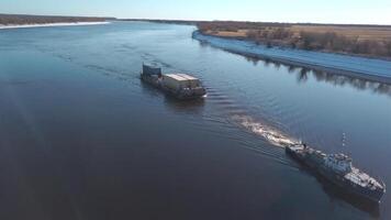 Top view of boat with cargo floating on river. Clip. Beautiful landscape with cargo boat floating on river. Cargo delivery by boat with trailer. Sea cargo transportation video