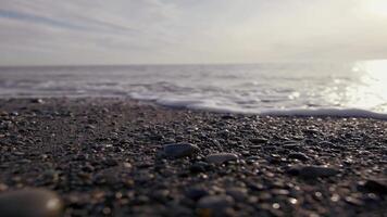 Strand. Aktion. schön Wellen von das Meer Laufen entlang das Stein und Sie können sehen das Schaum von das Meer und im das Hintergrund Sie können sehen das Licht von das Sonne. video