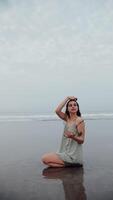 girl sitting on the beach on black wet sand with the ocean in the background video