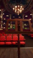 An empty theater with red seats and chandeliers video