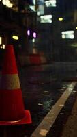 Bright Neon Traffic Cone on Rainy Asian City Road video