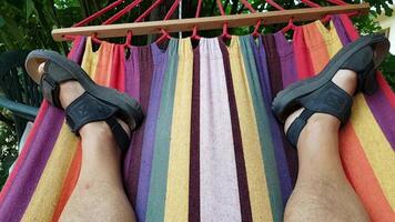 4k van een personen voeten swinging terwijl aan het liegen in een kleurrijk hangmat video