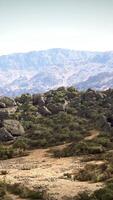 A majestic mountain range with trees and rocks in the foreground video