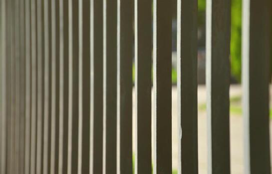 Close up view of a metal fence in perspective with blurred background photo