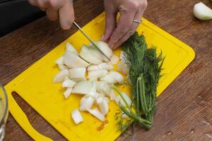 manos picar cebollas en un corte tablero. preparar vegetal ensalada. foto