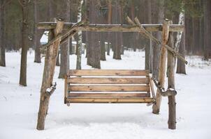 Homemade swing from logs and trees. Urban swinging fun made from natural materials. photo