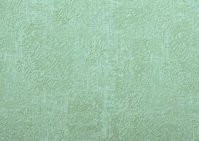 Background of green wallpaper or plaster wall with vintage swirl pattern. photo