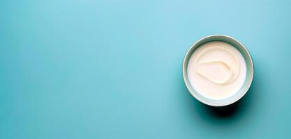 Bowl of sour cream isolated over blue background top view photo. photo