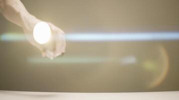 Male hand with a light torch on beige wall background. Action. Man is looking for something at home with a flashlight in his hand. video