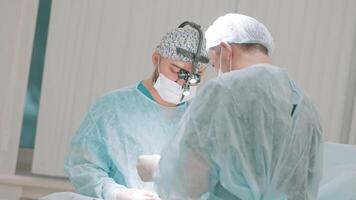 dos profesional doctores en médico mascaras y limpiar uniforme realizar un operación. acción. concepto de cuidado de la salud y medicamento. video