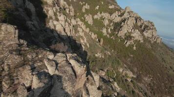 aéreo Visão do montanha alcance panorama azul nublado céu. tomada. surpreendente Rocha formações e verde declive, beleza do natureza. video