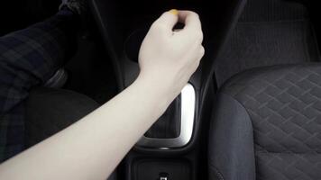 bestuurder vrouw controlerend auto- en schakelen de automatisch overdragen. actie. dichtbij omhoog top visie van vrouw hand- veranderen automatisch transmissie modus. video